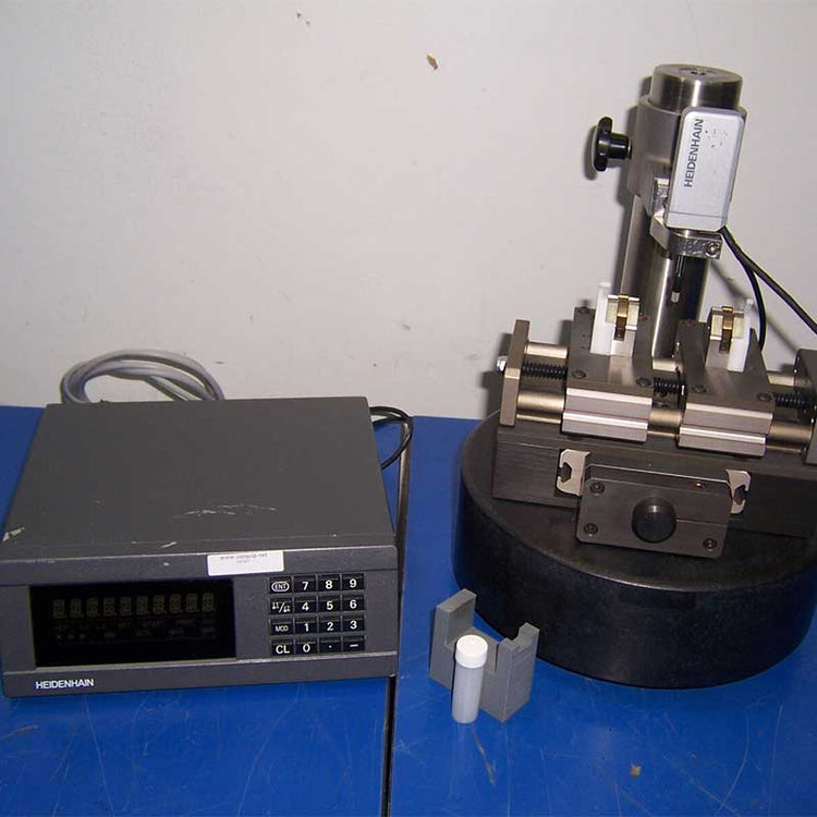 Scientific equipment including a digital display and mechanical component on a blue surface.
