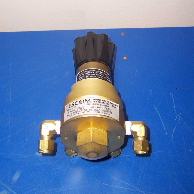 Brass pressure regulator with Tescom branding on a blue background