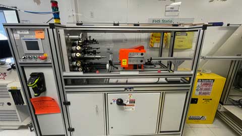 medical braiding machine with control panel and various components in a workshop setting